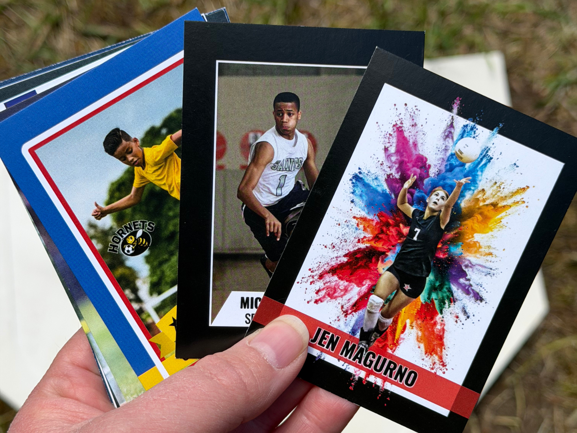 Three different styles of custom trading cards are shown side by side in a woman's hand.