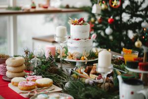 Assorted sweet treats and baked dish on table with cocktail during New Year holiday in house
